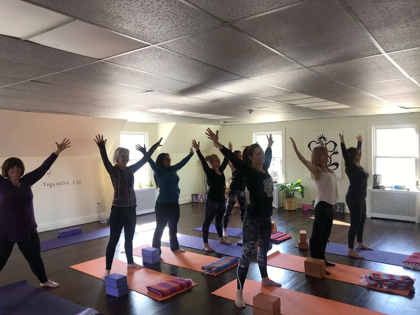 A somatic yoga session in progress at the Saddle River studio with a practitioner offering hands-on cueing