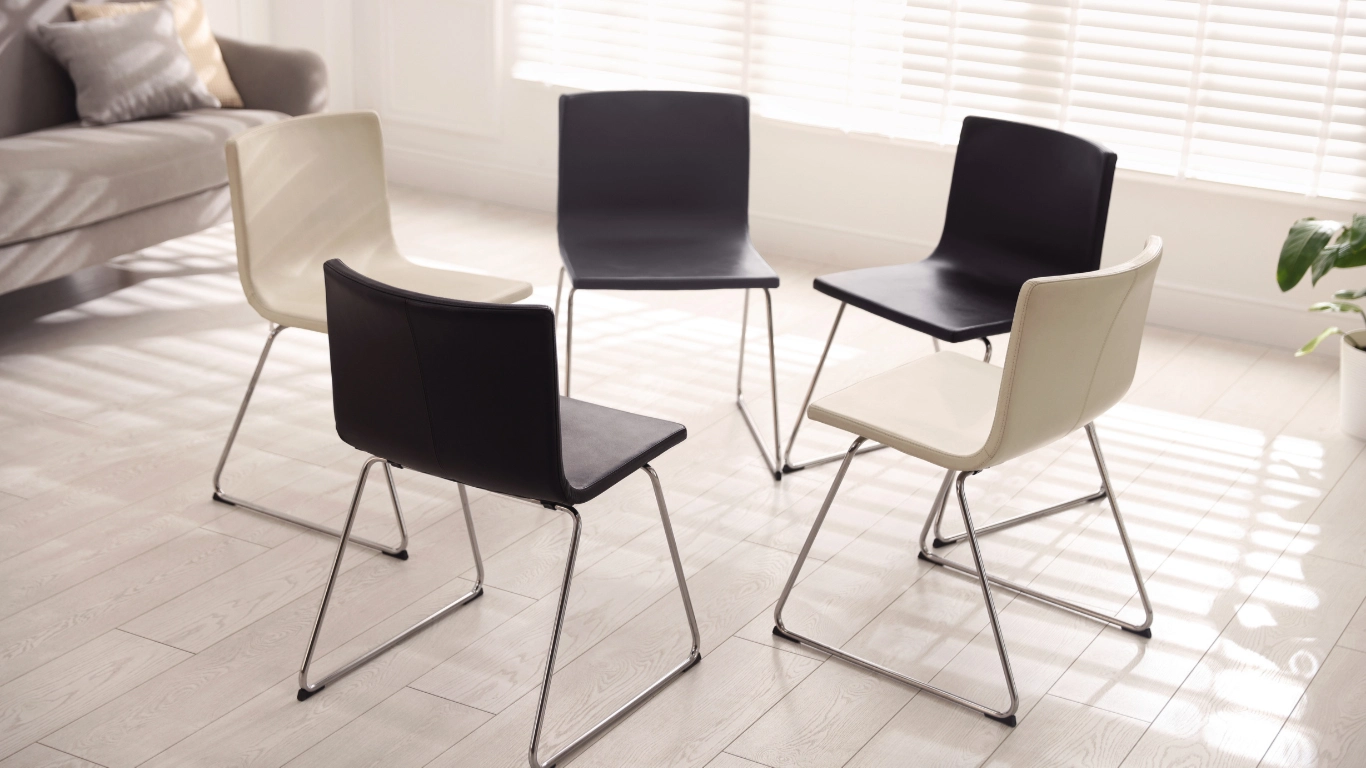 A small grief support group seated in a circle in Saddle River, NJ, offering long-term support beyond the first year