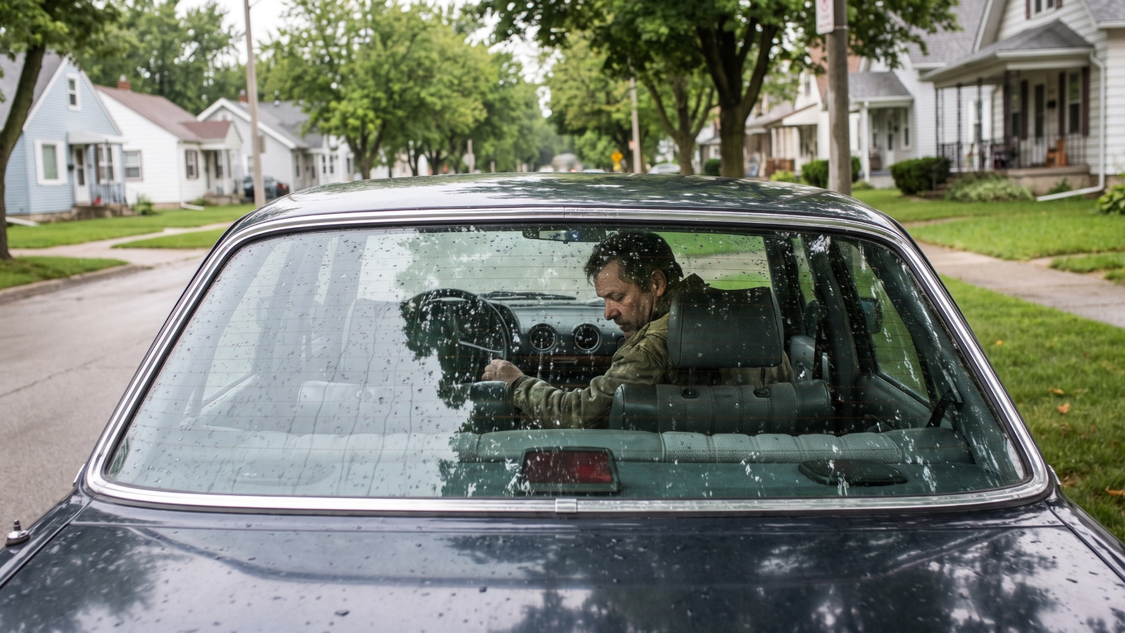 A man sitting alone in a parked car, representing grief support for men in Bergen County, NJ