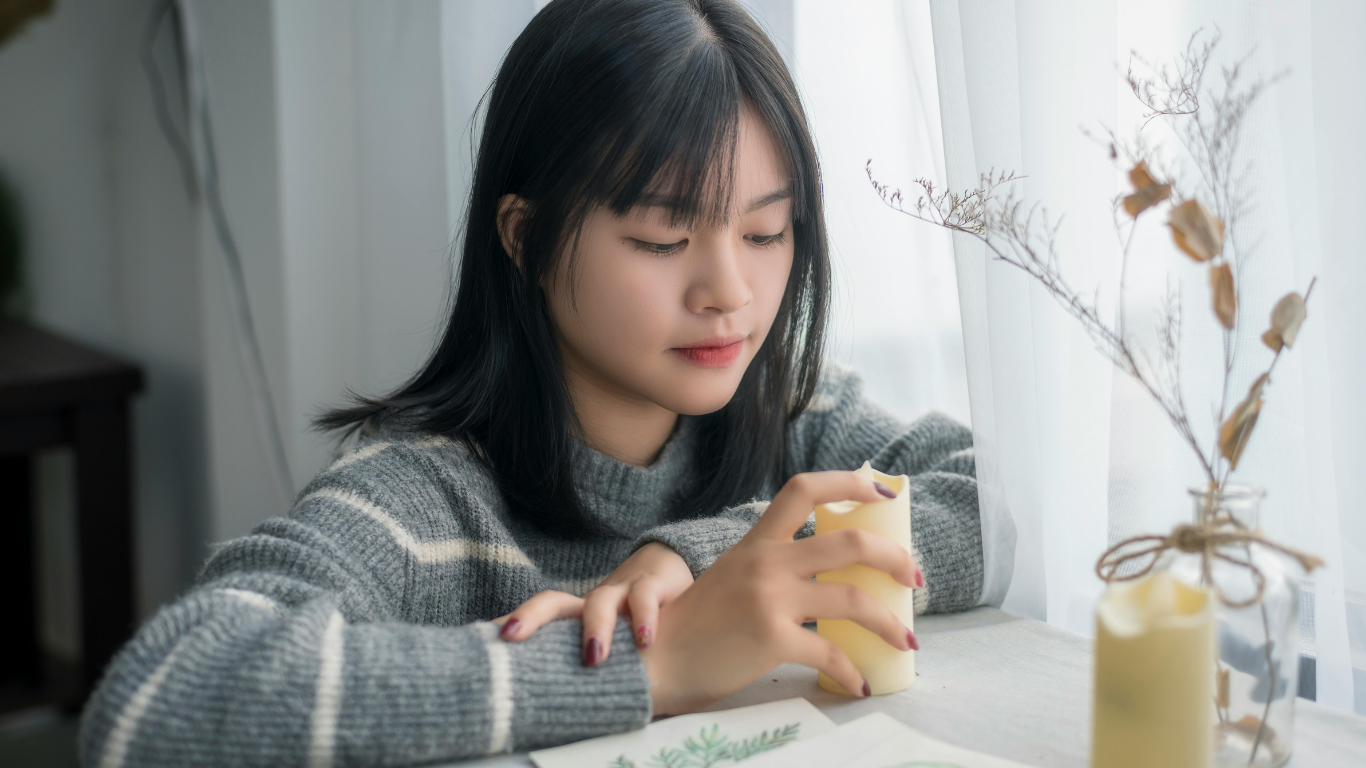 A solitary figure in soft natural light, holding a candle — symbolizing private disenfranchised grief that goes unrecognized