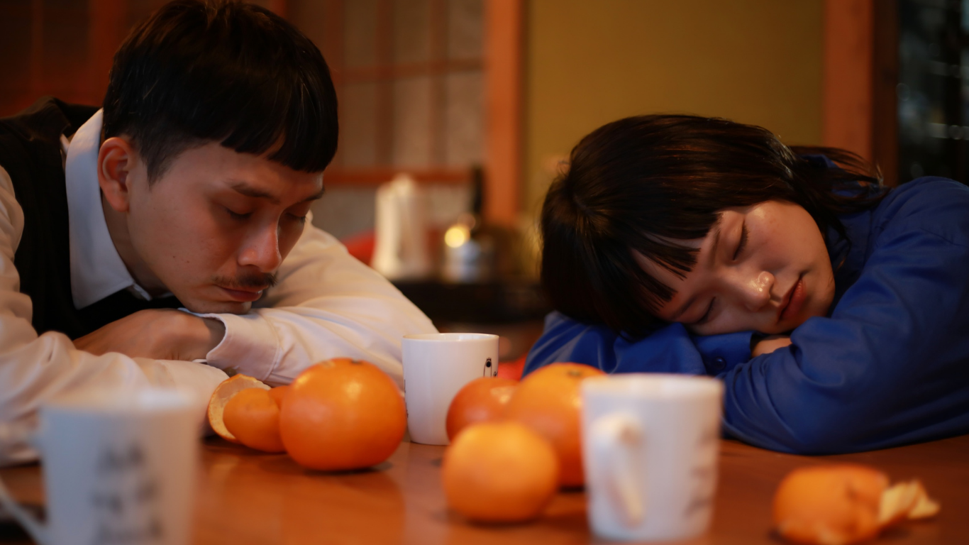 A caregiver pausing for a quiet moment with tea, eyes closed — a brief rest during anticipatory grief
