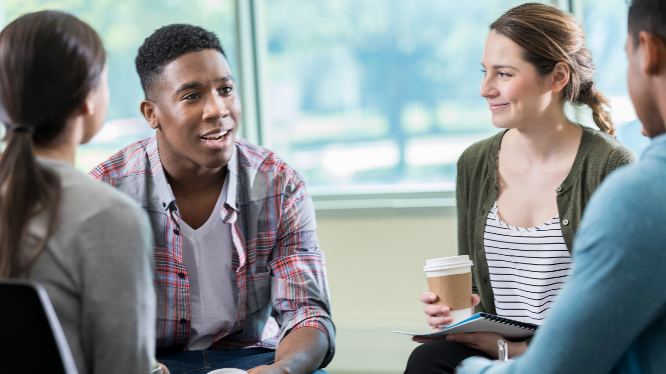Two people holding coffee cups in quiet conversation after a grief support group session at Grief Unbound
