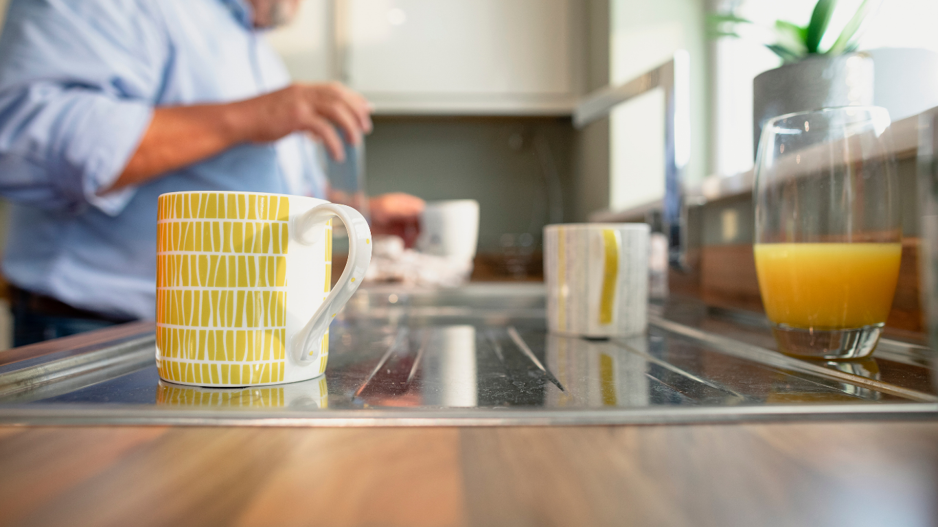 Two coffee mugs on a kitchen counter, one untouched — grief counseling for loss of a spouse